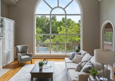 arched picture window, neutral furnishings, light and airy vibe, arched doorway, hardwood floors